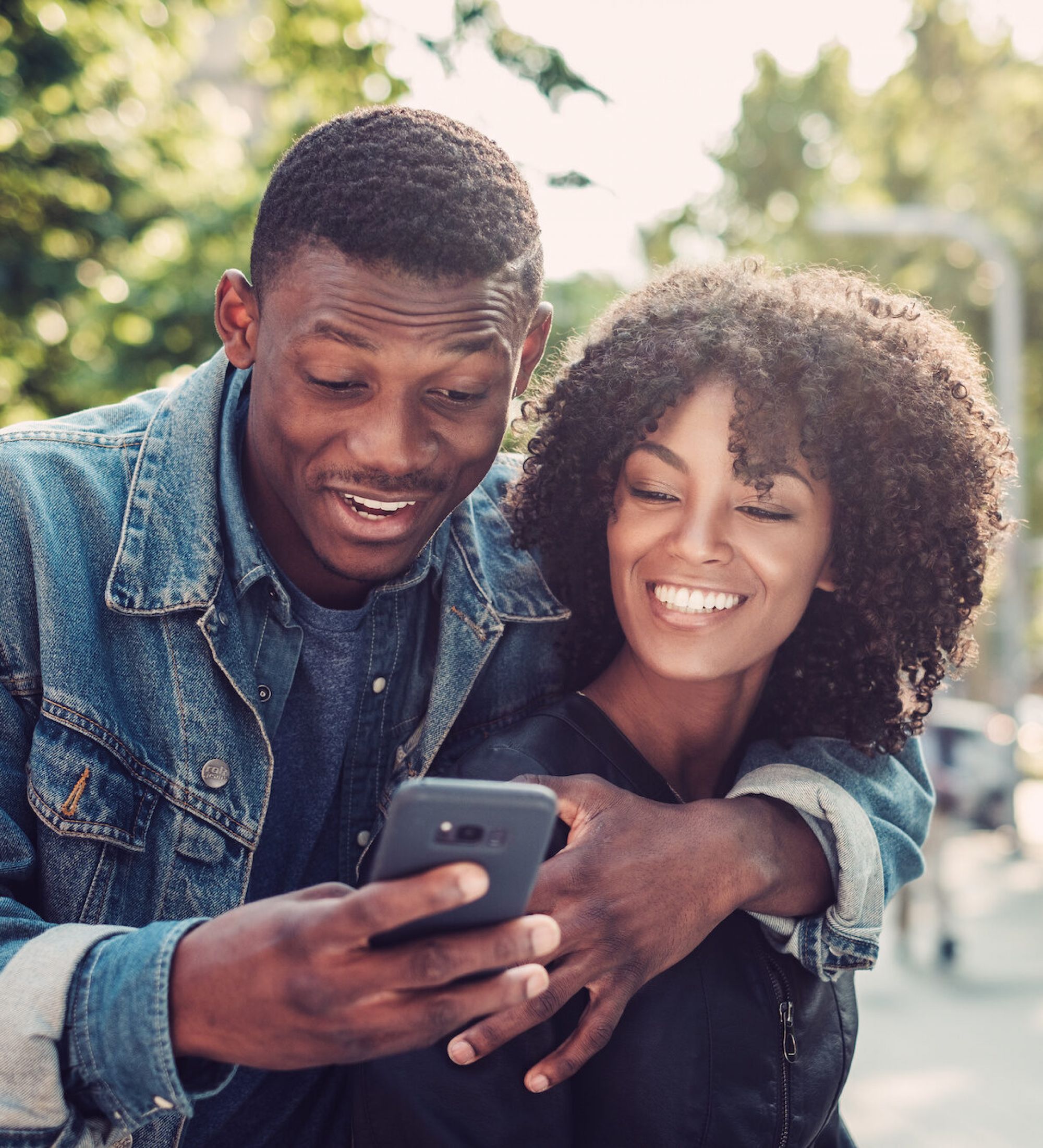 happy young couple looking at a phone in a Minneapolis park