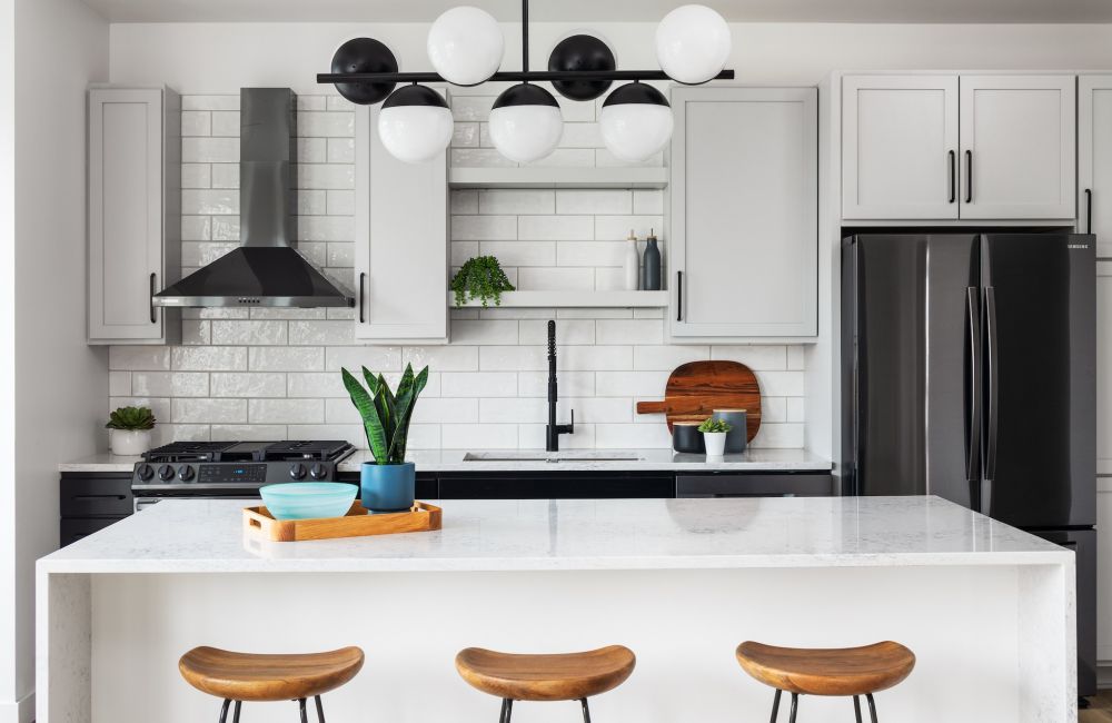 penthouse apartment kitchen with waterfall kitchen island, black stainless steel appliances, and quartz countertops