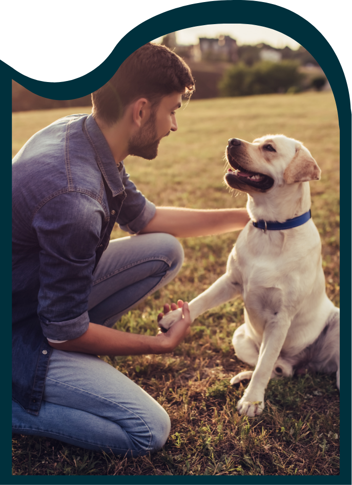 man shaking his dog's paw at dog run