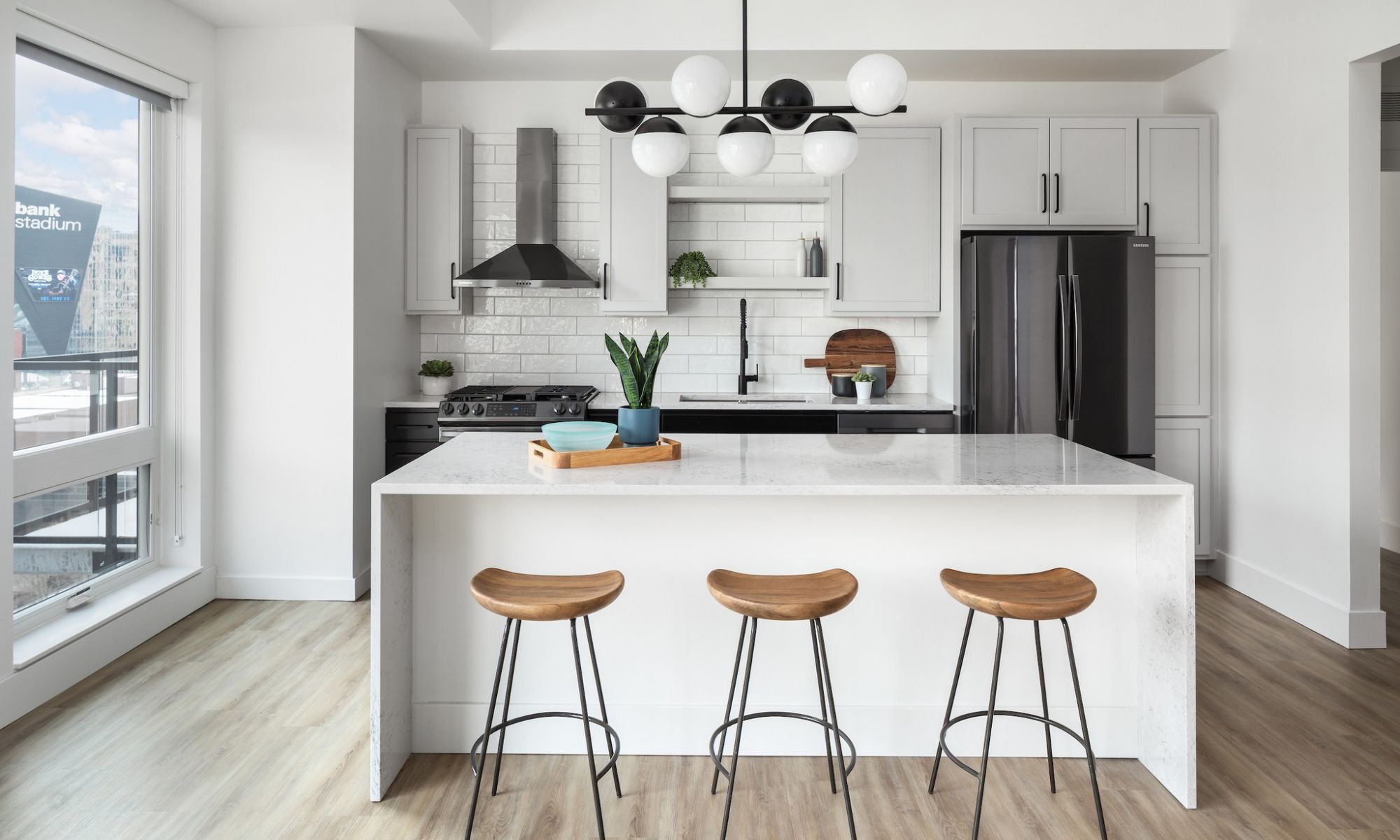 Waterfall kitchen island with pendant lighting and stainless steel appliances